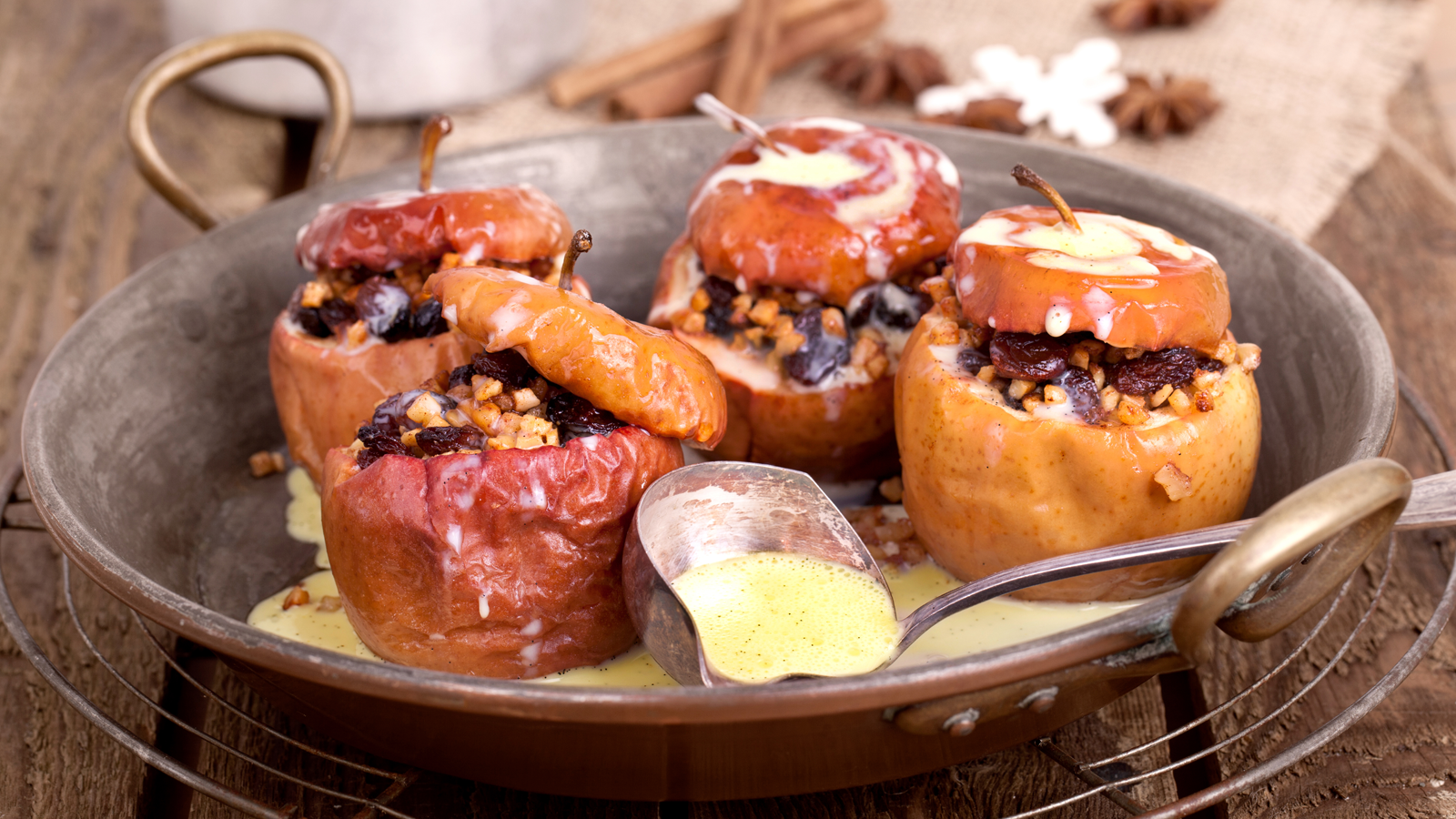 Baked Stuffed Apples in a serving dish with custard